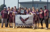 The Savage Lady Eagles, including players and coaches posing on field, holding a banner.  (Photo provided by Savage Lady Eagles)