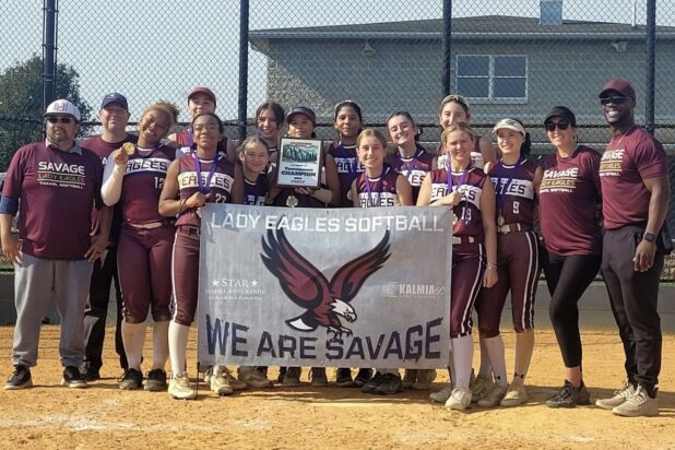 The Savage Lady Eagles, including players and coaches posing on field, holding a banner.  (Photo provided by Savage Lady Eagles)